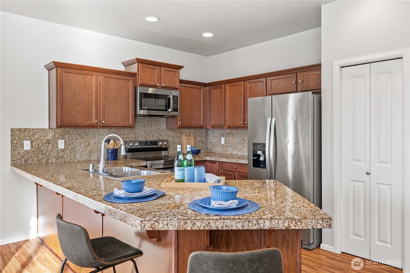 26219 243rd Place Southeast Maple Valley, WA 98038 - Photo 10 of 40 a kitchen with stainless steel appliances granite countertop a sink refrigerator and microwave