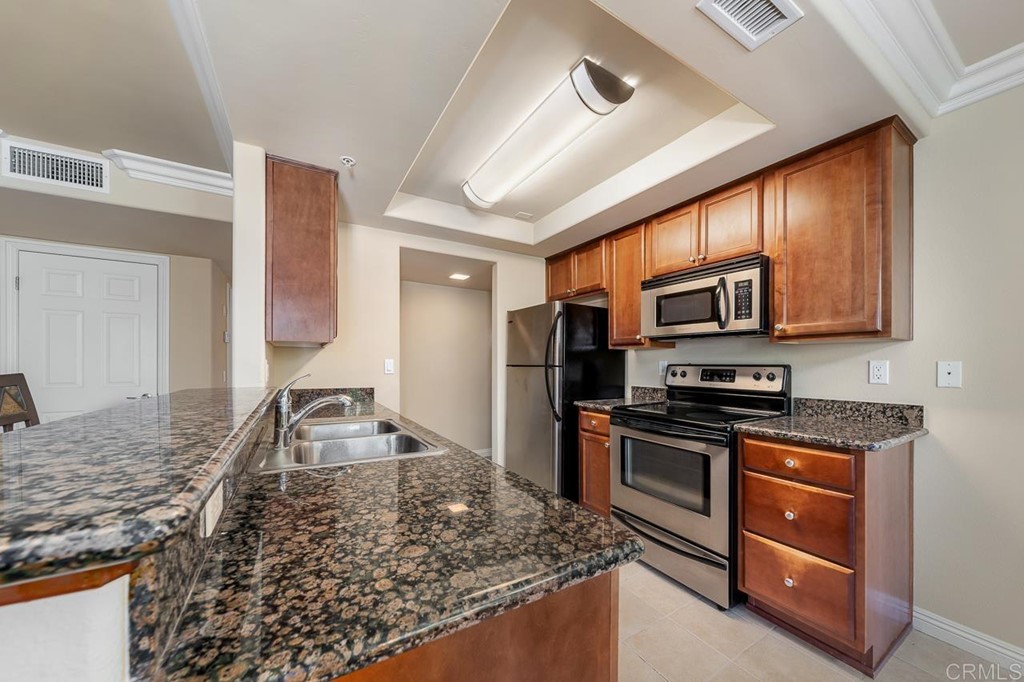 1434 Marshall Road, Unit 26 Alpine, CA 91901 - Photo 4 of 13 a kitchen with stainless steel appliances granite countertop a sink stove microwave and refrigerator