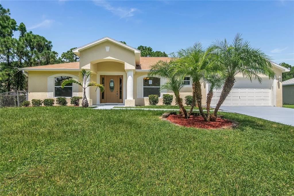 911 Pandora Road Southeast Palm Bay, FL 32909 - Photo 1 of 1 a front view of a house with garden