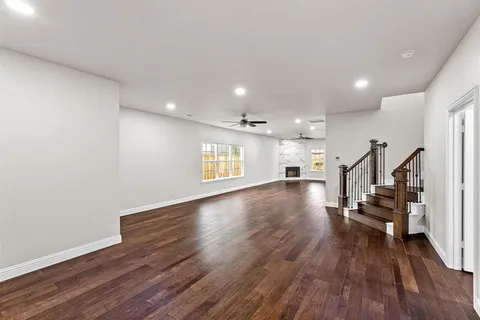 a view of empty room with wooden floor and stairs