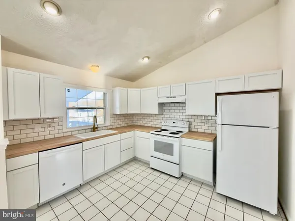 a kitchen with white cabinets and white appliances