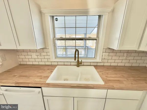 a view of a sink a microwave and window in a kitchen