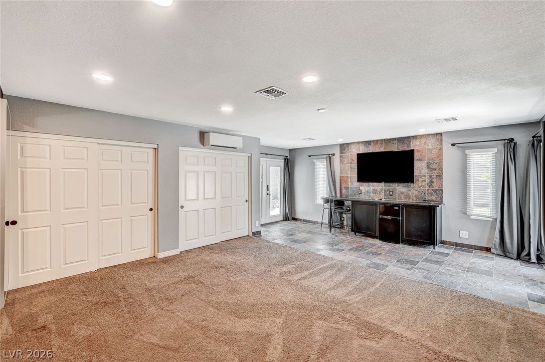 4153 Woodcrest Road Las Vegas, NV 89121 - Photo 28 of 58 A versatile living area with a distinct flooring transition and built-in entertainment bar awaits.