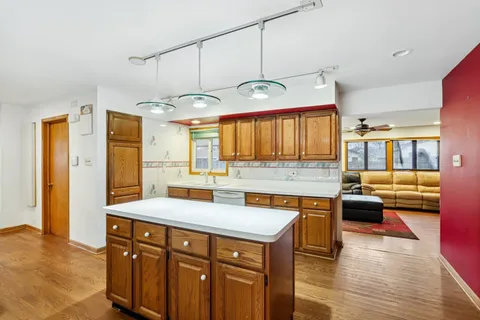 a kitchen with a sink cabinets and wooden floor
