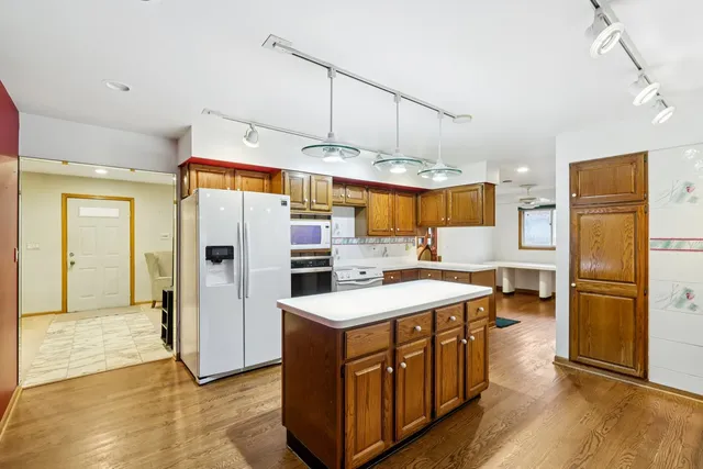 a kitchen with stainless steel appliances granite countertop a refrigerator a sink and a stove