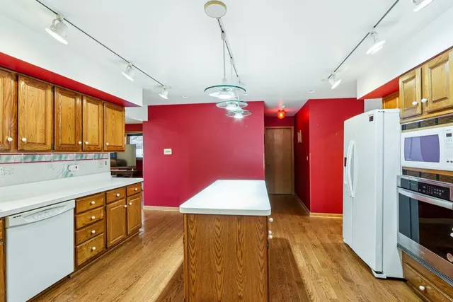 a kitchen with stainless steel appliances granite countertop a refrigerator a stove and a wooden floors