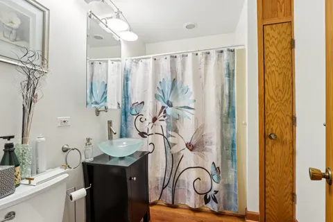 a bathroom with a granite countertop sink a mirror and a shower curtain