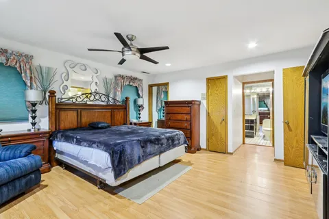 a bedroom with a large bed a flat tv screen and dresser