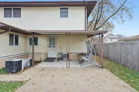 a view of a house with backyard and a tree