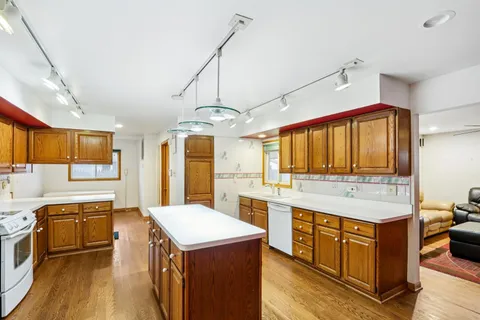 a kitchen that has a lot of cabinets in it and wooden floors