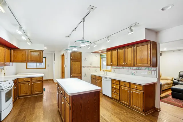 a kitchen that has a lot of cabinets in it and wooden floors