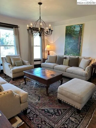 a living room with furniture a window and a chandelier