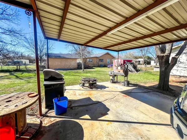 a view of a backyard with table and chairs and a barbeque