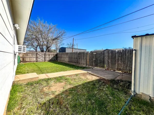 a view of a backyard with wooden fence