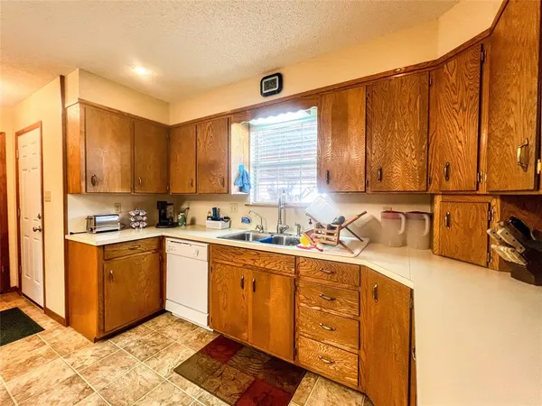 a kitchen with stainless steel appliances granite countertop a sink window and cabinets