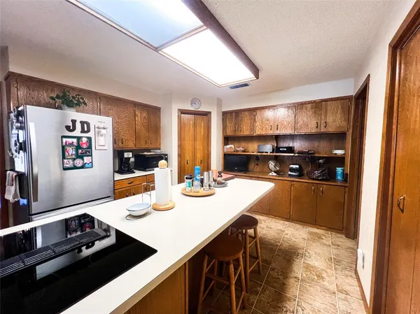 a kitchen with kitchen island a stove a sink and a refrigerator