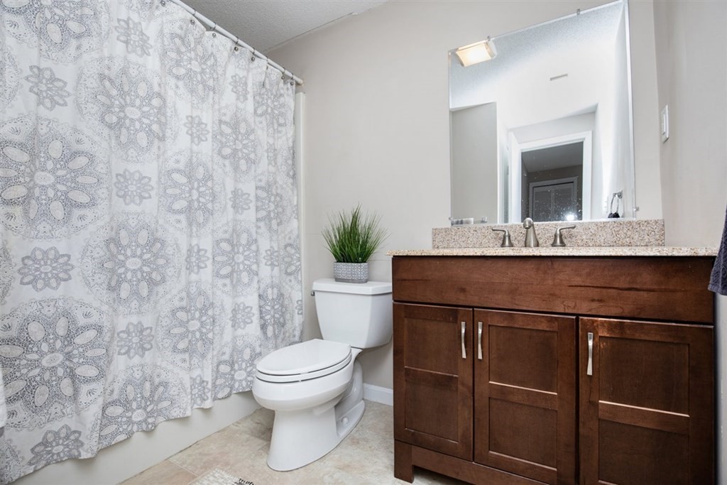 35 Prospect Street, Unit 301 Woburn, MA 01801 - Photo 16 of 19 a bathroom with a granite countertop toilet sink and mirror