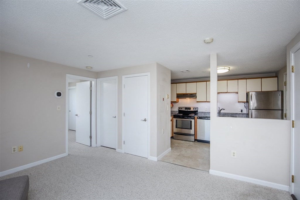 35 Prospect Street, Unit 301 Woburn, MA 01801 - Photo 5 of 19 a kitchen with a refrigerator and a stove top oven