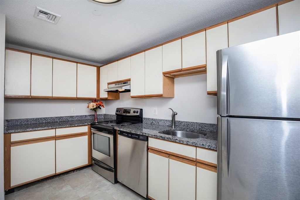 35 Prospect Street, Unit 301 Woburn, MA 01801 - Photo 7 of 19 a kitchen with stainless steel appliances granite countertop a refrigerator a stove a sink and white cabinets