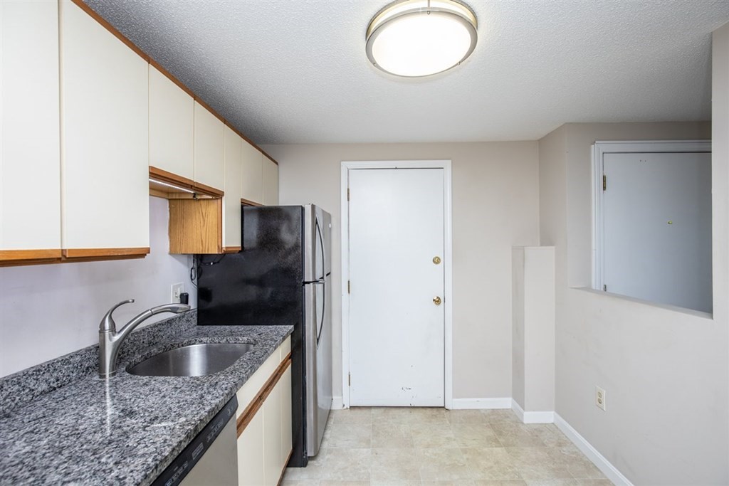 35 Prospect Street, Unit 301 Woburn, MA 01801 - Photo 9 of 19 a kitchen with stainless steel appliances granite countertop a sink a refrigerator and a stove