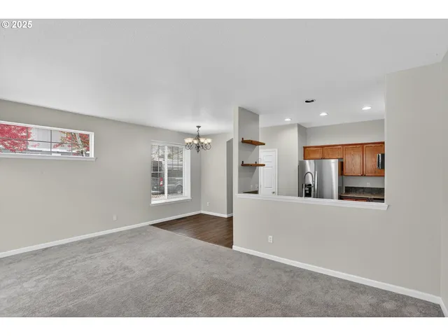 an empty room with wooden floor and chandelier