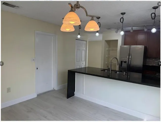 a kitchen with stainless steel appliances granite countertop a refrigerator a oven and a sink with granite countertops