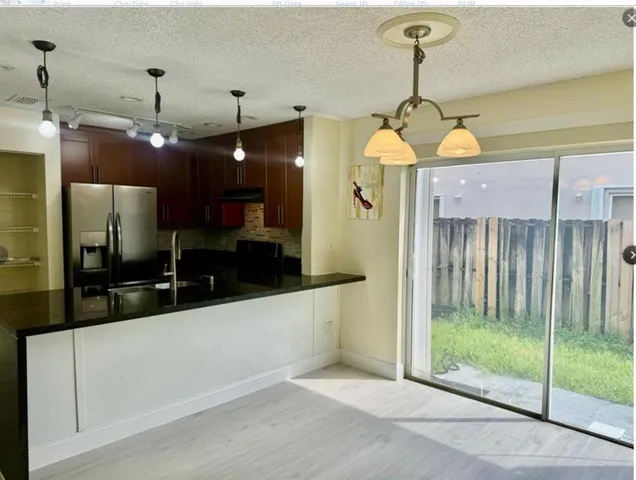 a kitchen with stainless steel appliances granite countertop a sink a refrigerator and a stove