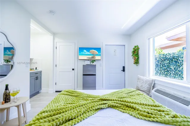 a bedroom with a bed window and a flat screen tv