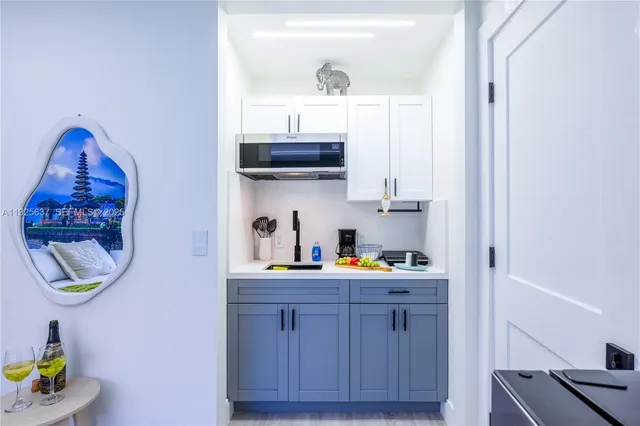 a kitchen with a sink a stove and a painting on the wall