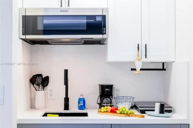 a kitchen with stainless steel appliances kitchen island granite countertop a sink and a microwave