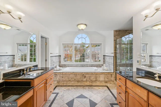 a large white kitchen with a large window and stainless steel appliances