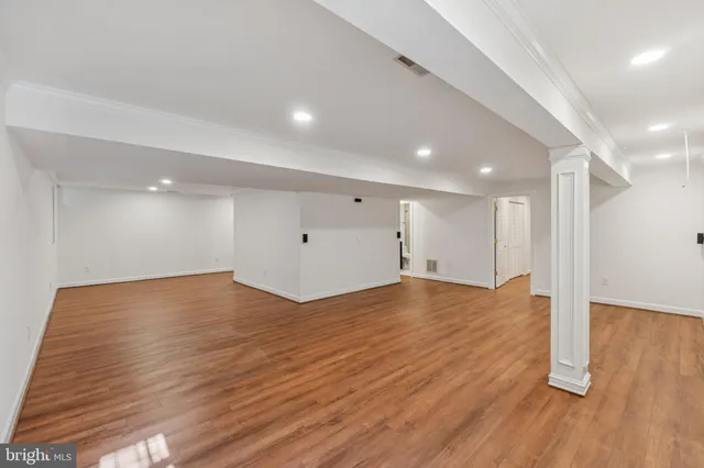 a view of an empty room with wooden floor
