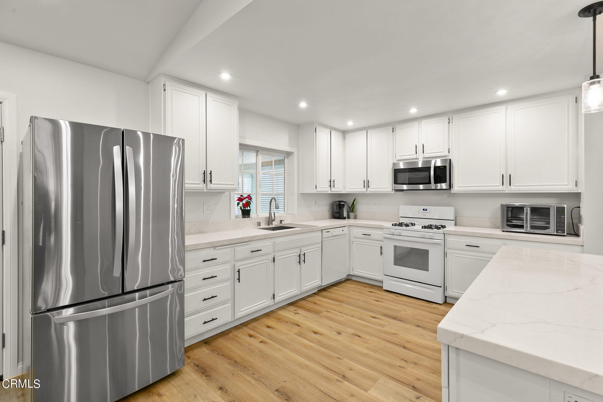 2531 Raft Lane Oxnard, CA 93035 - Photo 10 of 42 a kitchen with white cabinets stainless steel appliances and window