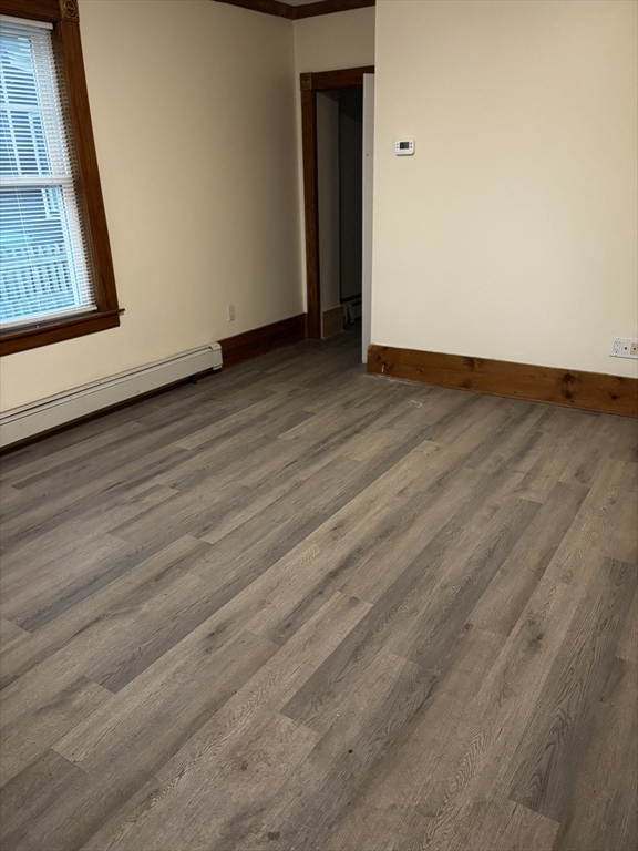 14 Gilkey Court, Unit 1 Watertown, MA 02472 - Photo 5 of 12 a view of an empty room with wooden floor and a window
