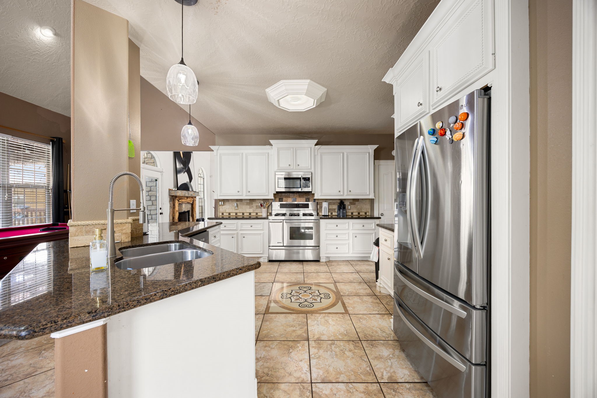 21427 Tophill Drive Spring, TX 77388 - Photo 16 of 50 a kitchen with stainless steel appliances granite countertop a refrigerator a stove and a sink with large cabinets