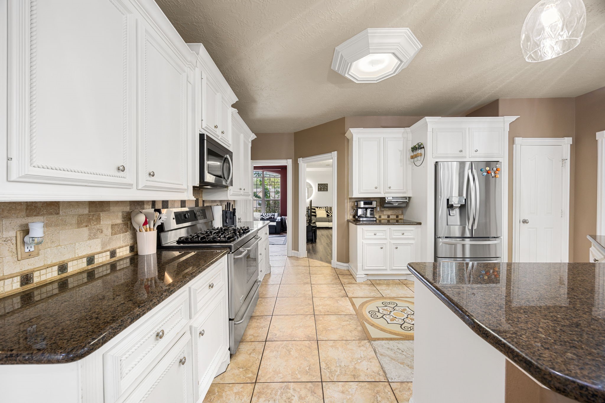 21427 Tophill Drive Spring, TX 77388 - Photo 19 of 50 a large kitchen with granite countertop a stove a sink dishwasher a refrigerator and white cabinets with wooden floor