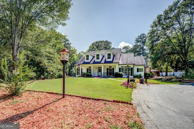 a view of a house with a big yard and large trees