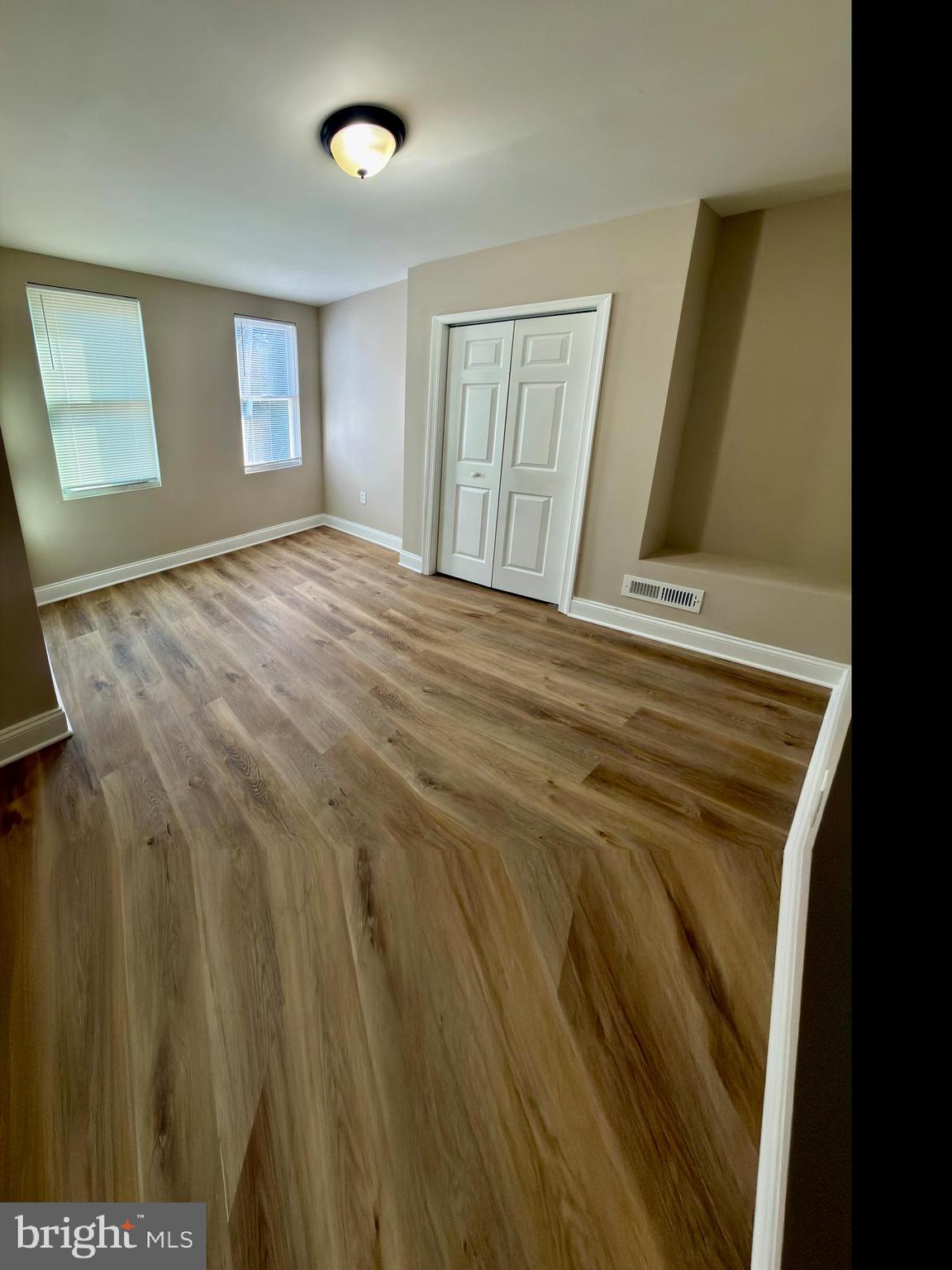 2129 Federal Street Baltimore, MD 21213 - Photo 15 of 27 a view of an empty room with wooden floor and a window