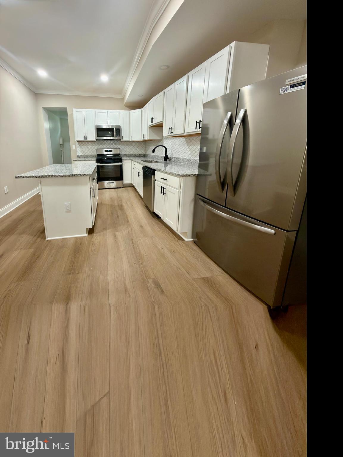 2129 Federal Street Baltimore, MD 21213 - Photo 3 of 27 a kitchen with stainless steel appliances granite countertop a refrigerator sink and cabinets