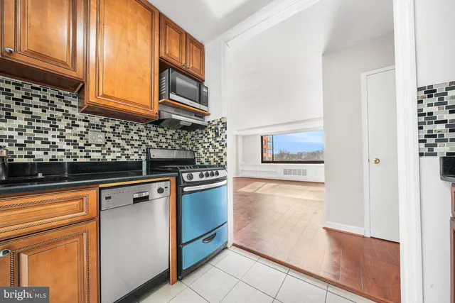 a kitchen with stainless steel appliances granite countertop a refrigerator and a stove top oven