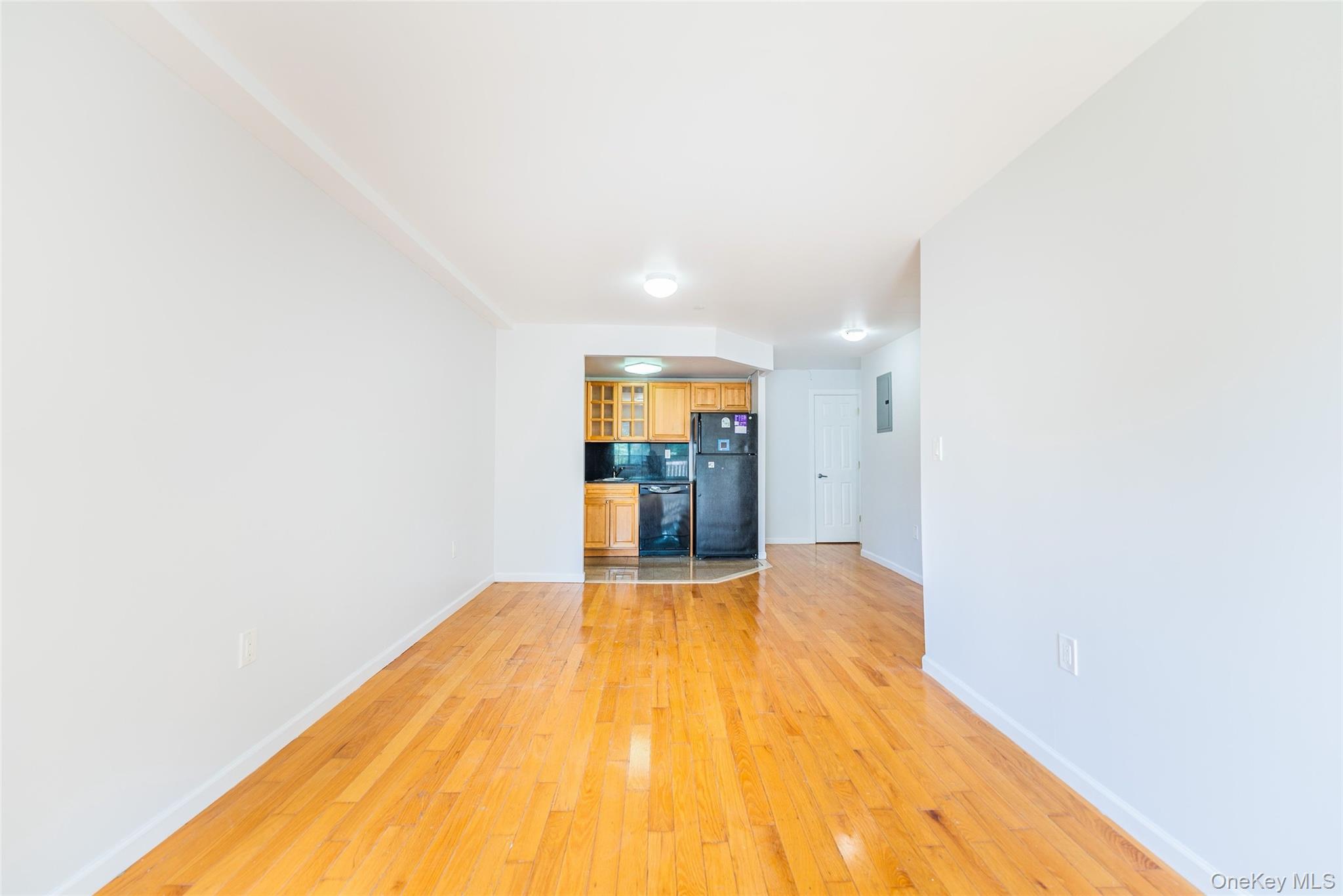112-26 38th Avenue, Unit 4A Queens, NY 11368 - Photo 12 of 18 a view of a big room with wooden floor and a bathroom