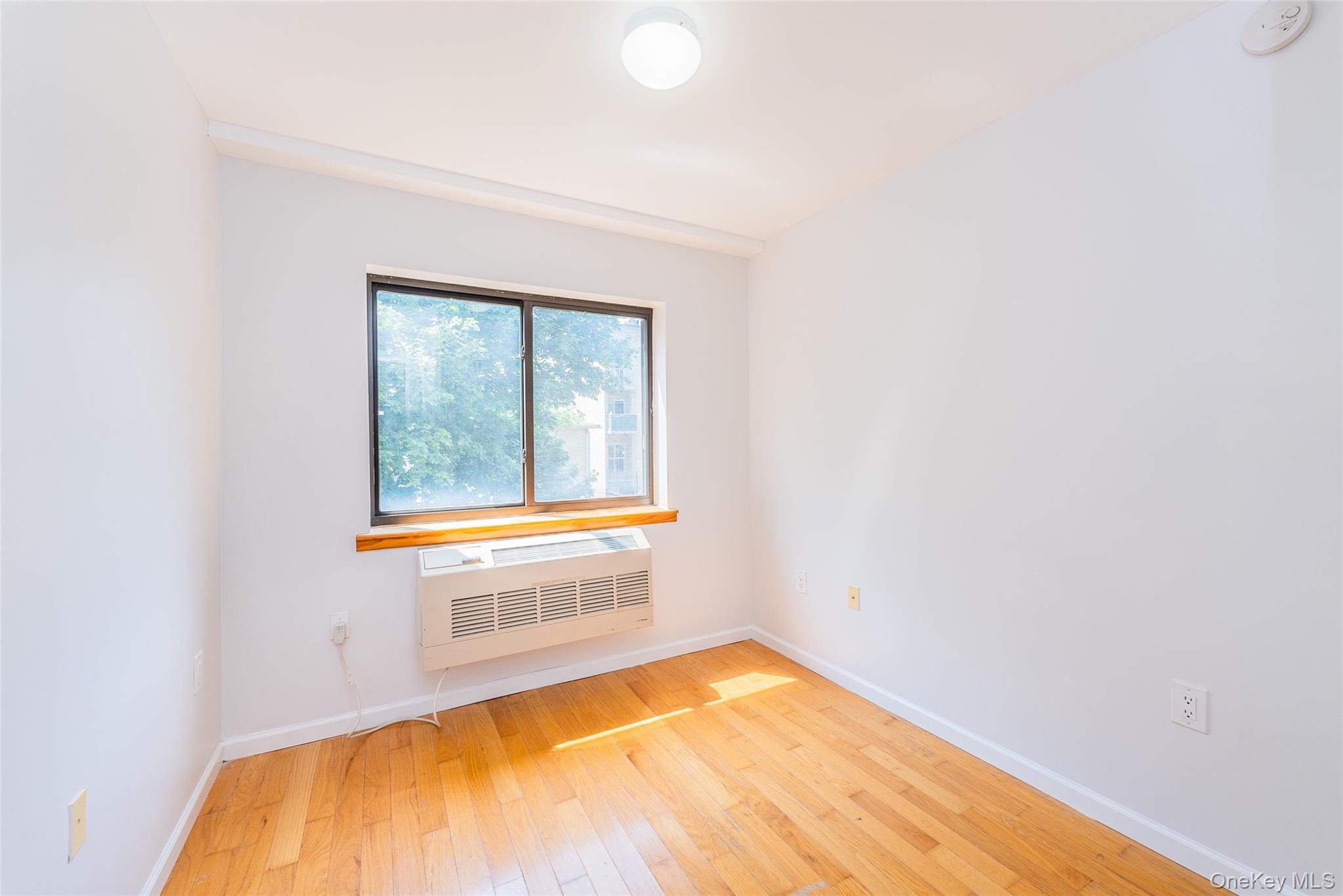112-26 38th Avenue, Unit 4A Queens, NY 11368 - Photo 15 of 18 a view of a room with wooden floor and a window
