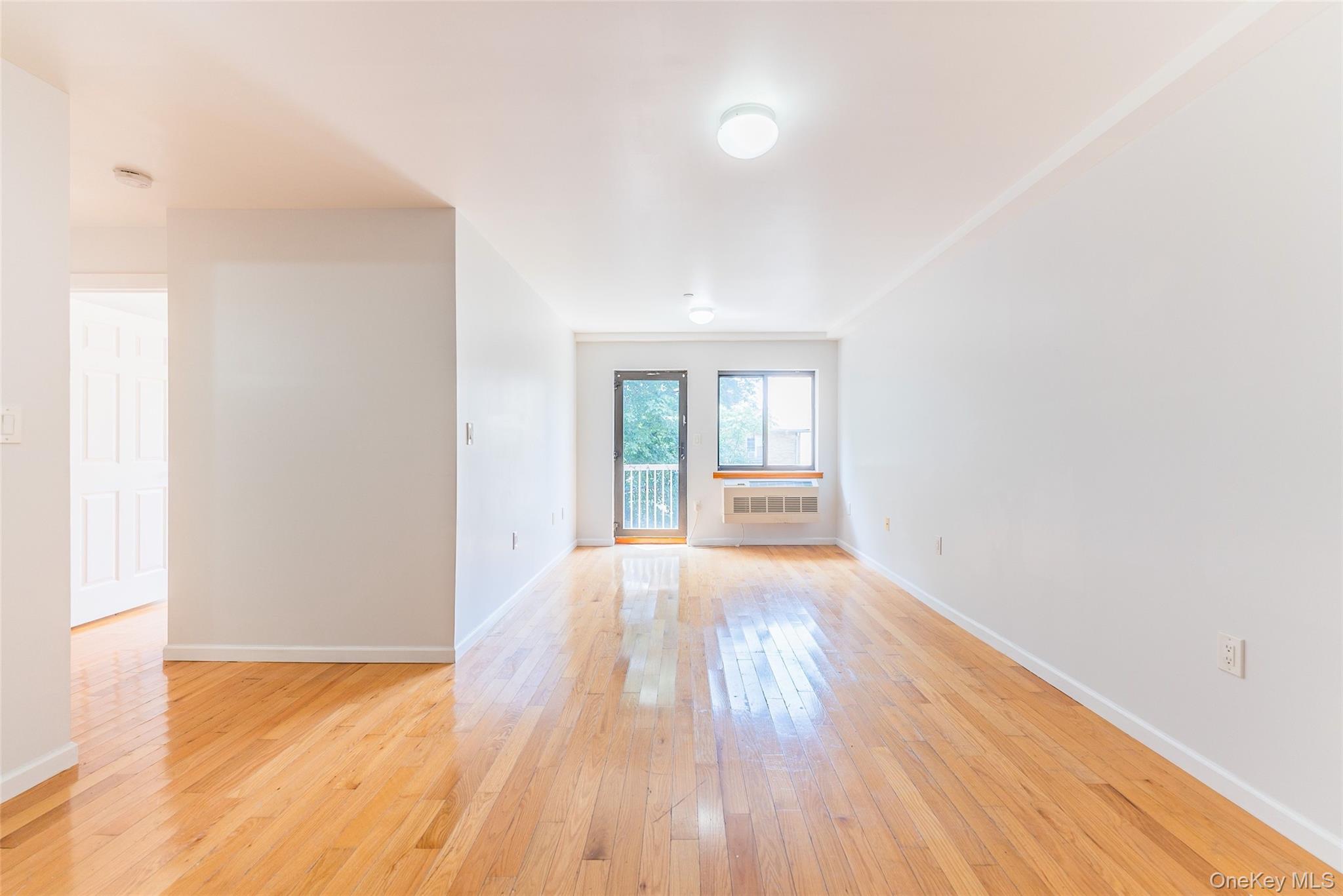 112-26 38th Avenue, Unit 4A Queens, NY 11368 - Photo 5 of 18 a view of an empty room with wooden floor and a window