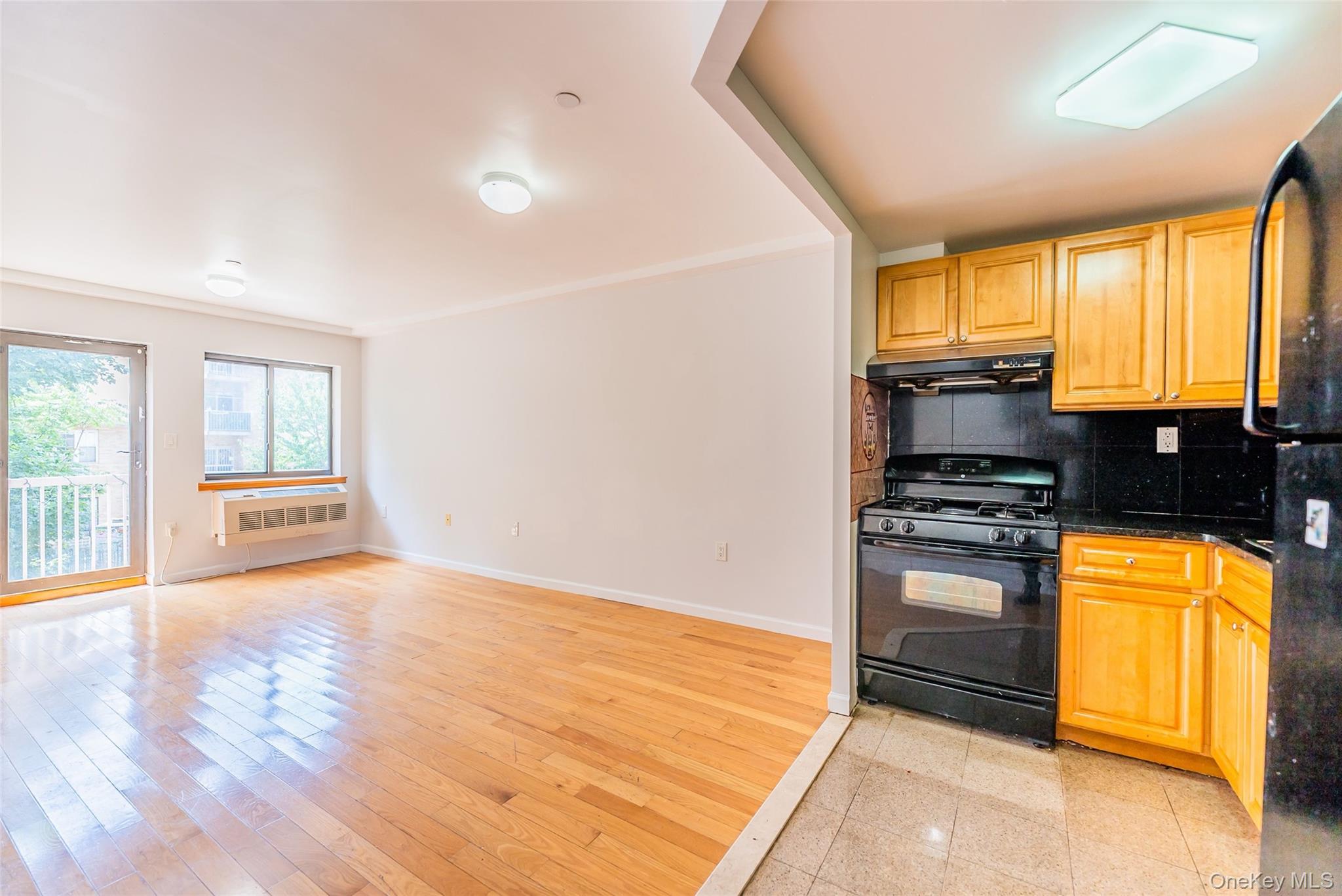 112-26 38th Avenue, Unit 4A Queens, NY 11368 - Photo 8 of 18 a view of a kitchen with wooden floor and a window