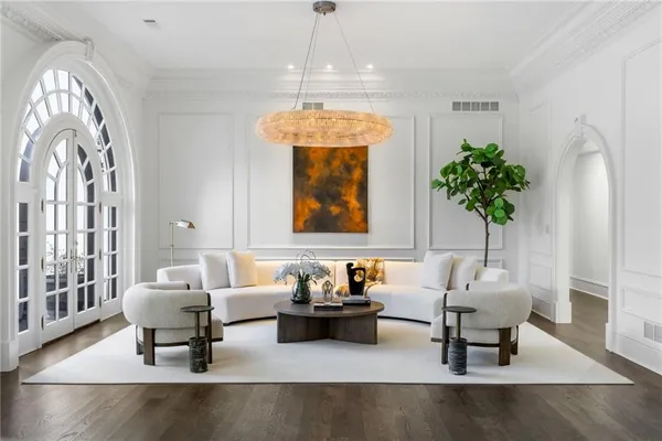 a living room with furniture a fireplace and a chandelier