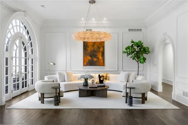 a living room with furniture a fireplace and a chandelier