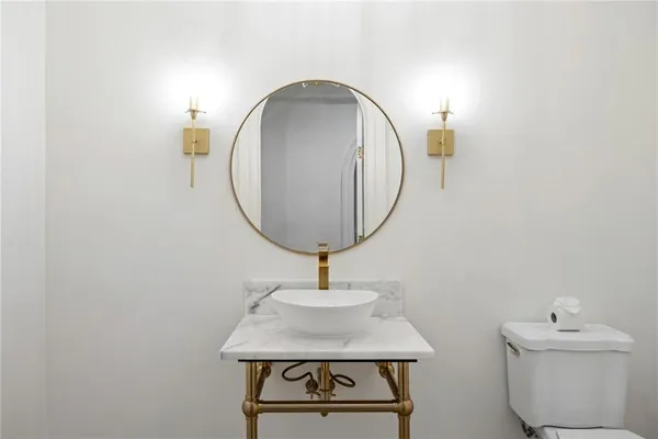 a bathroom with a granite countertop sink a toilet and a mirror