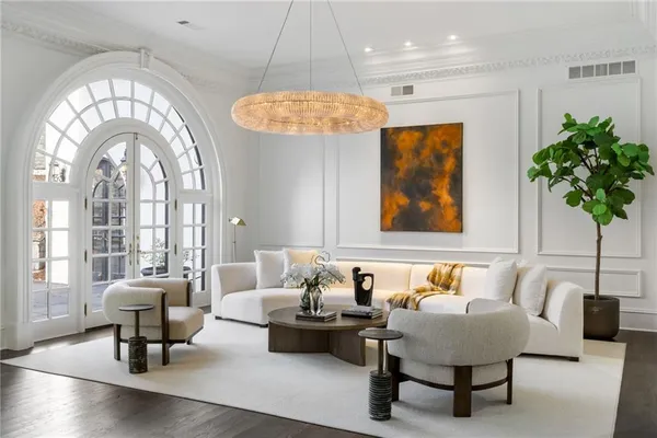 a living room with furniture a fireplace and a chandelier