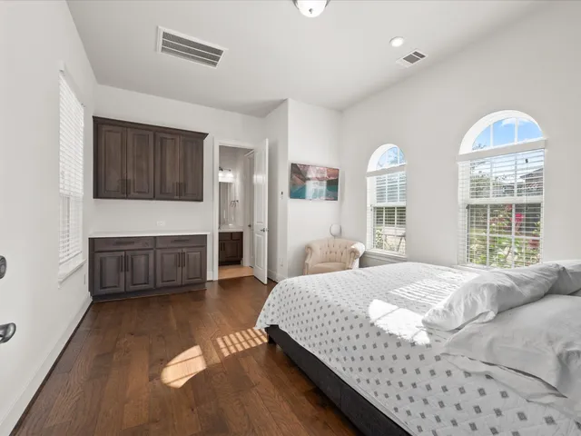 a roof deck with table and chairs under an umbrella with large trees