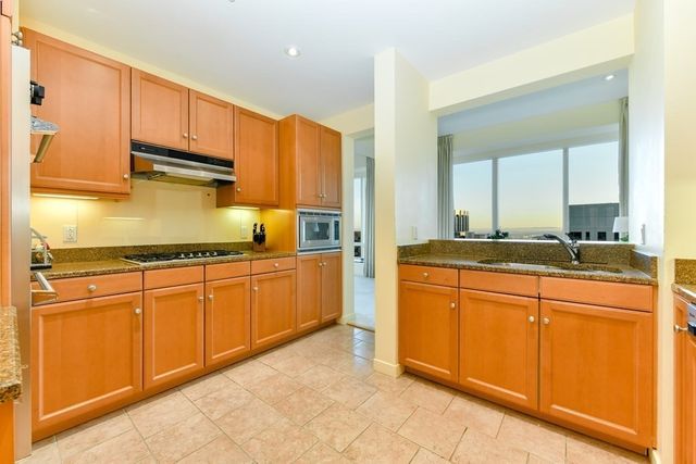 a kitchen with granite countertop a sink stainless steel appliances and cabinets